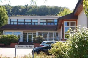 Ein Gebäude, Dorfgemeinschaftshaus. Im Vordergrund ist der Straßenname "Christoph-Kalb-Haus" auf einem Schild abgebildet.