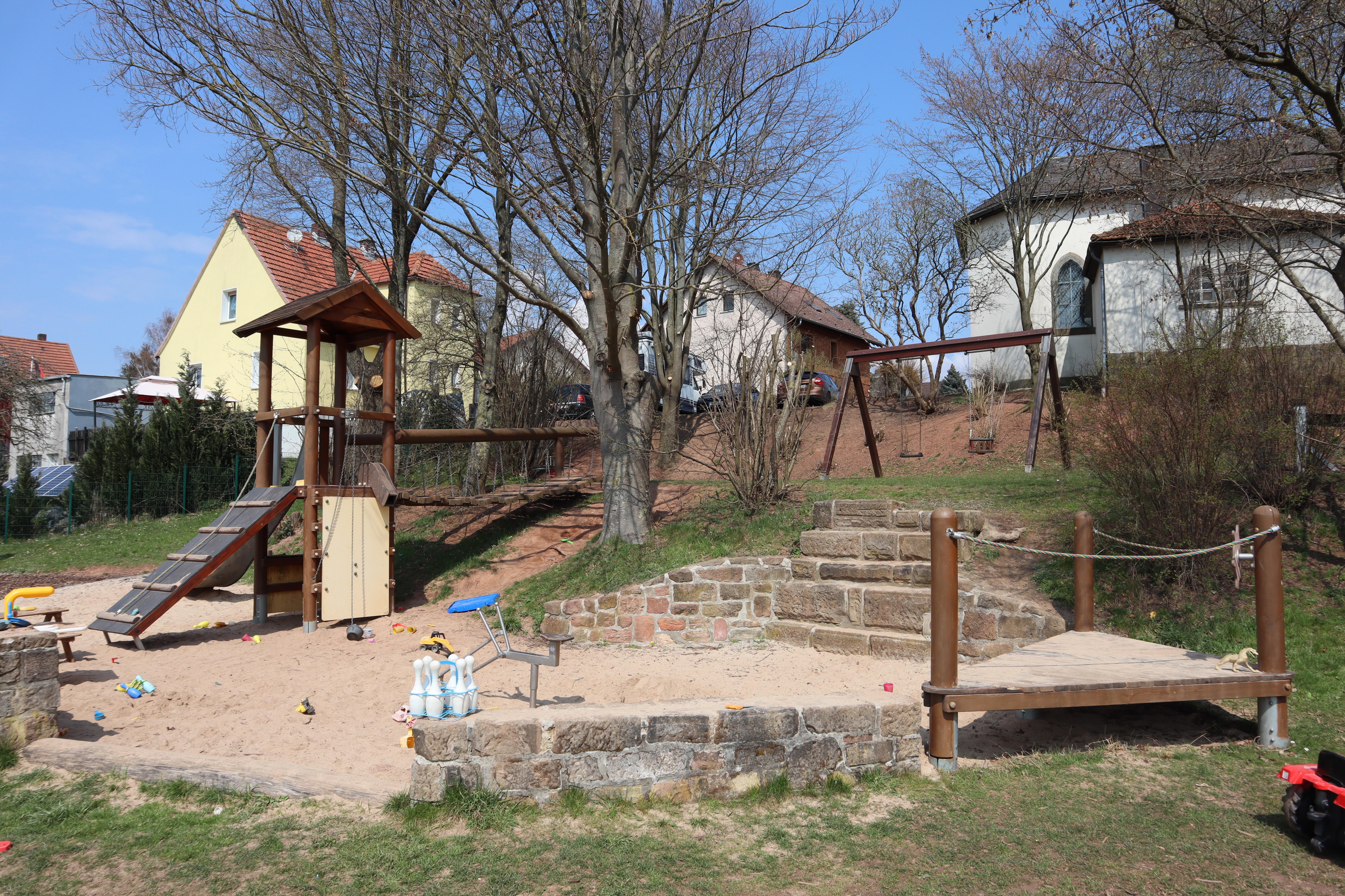 Spielplatz_Tiefengruben Spielgeräte auf dem Spielplatz vor Büschen und Bäumen
