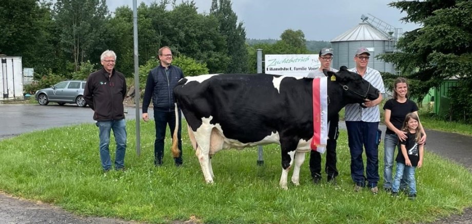 Zu sehen ist die 100.000-Literkuh Ilonka mit ihren Besitzern sowie dem Bürgermeister der Gemeinde Neuhof.