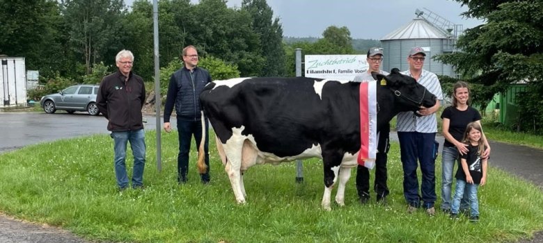 Zu sehen ist die 100.000-Literkuh Ilonka mit ihren Besitzern sowie dem Bürgermeister der Gemeinde Neuhof.