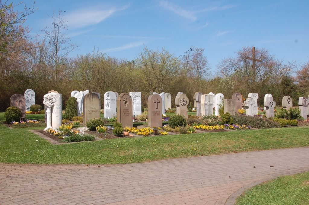 Zu sehen sind Pflanzgräber auf einem Friedhof. In die Höhe ragen jeweils die Grabsteine der einzelnen Gräber.
